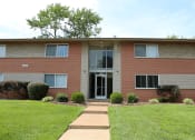 Thumbnail 14 of 17 - a brick building with a lawn in front of it