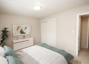 Thumbnail 8 of 23 - a bedroom with a bed and a dresser