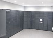 Thumbnail 13 of 20 - A row of Amazon locker units are lined up in a room.