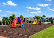 Thumbnail 15 of 20 - A playground with a red and blue arch and a yellow slide.