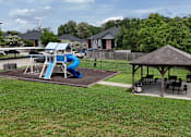 Thumbnail 20 of 27 - A playground with a blue slide and a gazebo.