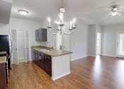Thumbnail 1 of 27 - A kitchen with a black refrigerator and wooden floors.