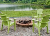 Thumbnail 10 of 23 - three green chairs sitting around a fire pit near a lake