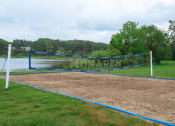 Thumbnail 14 of 23 - a volleyball court with a lake in the background
