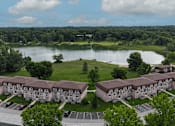 Thumbnail 32 of 32 - A large building complex is situated in front of a lake.