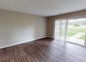 Thumbnail 6 of 32 - A room with wooden flooring and sliding glass doors.