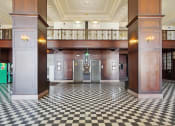 Thumbnail 8 of 29 - the lobby of a building with pillars and a checkered floor
