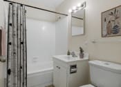 Thumbnail 6 of 25 - a bathroom with white fixtures and a black and white shower curtain