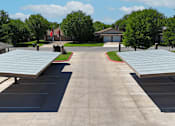 Thumbnail 18 of 30 - A parking lot with a building in the background.