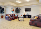 Thumbnail 10 of 30 - A living room with a brown leather couch and a coffee table.