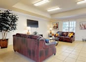 Thumbnail 11 of 30 - A living room with a red couch and a television.