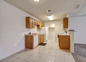 Thumbnail 3 of 30 - A kitchen with white walls and brown cabinets.