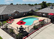 Thumbnail 13 of 30 - A black fence surrounds a pool with a red umbrella.