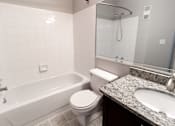 Thumbnail 4 of 35 - A white toilet sits next to a white bathtub in a bathroom.
