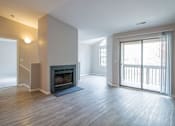 Thumbnail 1 of 35 - A spacious living room with a fireplace and sliding glass doors.