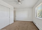 Thumbnail 7 of 15 - an empty bedroom with white walls and a ceiling fan