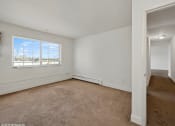 Thumbnail 6 of 15 - an empty living room with carpet and a window