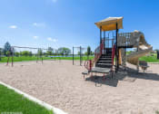 Thumbnail 11 of 15 - a playground with a swing set and a slide at an apartment complex