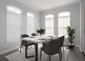 Thumbnail 5 of 33 - a dining room with windows and a table with a vase of flowers on top of it