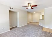 Thumbnail 7 of 33 - A room with a ceiling fan and carpeted floor.