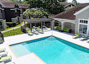 Thumbnail 22 of 33 - A swimming pool with a deck and lounge chairs.