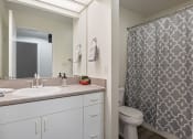 Thumbnail 3 of 15 - a bathroom with a shower and a sink and a toilet