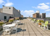 Thumbnail 8 of 15 - a roof terrace with tables and chairs and buildings in the background