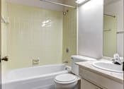 Thumbnail 15 of 24 - A white toilet sits next to a bathtub in a bathroom.