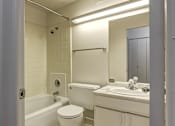 Thumbnail 16 of 24 - A white bathroom with a toilet, sink, and bathtub.
