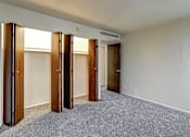 Thumbnail 13 of 24 - A room with a carpeted floor and four wooden doors.