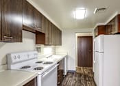 Thumbnail 1 of 24 - A kitchen with white appliances and wood cabinets.