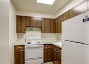 Thumbnail 2 of 24 - A kitchen with a white stove and refrigerator.