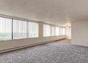 Thumbnail 7 of 24 - A room with a carpeted floor and a window with blinds.