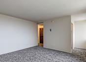 Thumbnail 11 of 24 - A room with a carpeted floor and a door in the background.