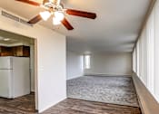 Thumbnail 8 of 24 - A room with a ceiling fan and a refrigerator.