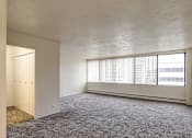 Thumbnail 5 of 24 - A room with a carpeted floor and a window with blinds.