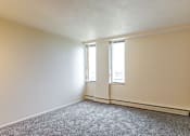 Thumbnail 12 of 24 - A room with a grey carpet and two windows.