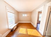 Thumbnail 21 of 32 - A room with a window and a wooden floor.