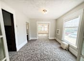 Thumbnail 19 of 32 - A room with a carpeted floor and a window.