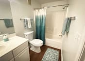 Thumbnail 3 of 18 - A white toilet sits next to a sink in a bathroom.
