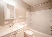 Thumbnail 16 of 25 - A white bathroom with a toilet, sink, and bathtub.
