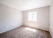 Thumbnail 14 of 25 - A room with a carpeted floor and a window letting in sunlight.