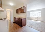 Thumbnail 10 of 25 - A kitchen with white appliances and brown cabinets.