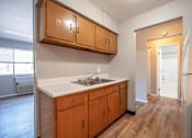Thumbnail 2 of 25 - A kitchen with wooden cabinets and a white countertop.