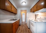 Thumbnail 1 of 25 - A kitchen with white appliances and wooden cabinets.