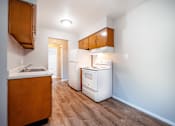 Thumbnail 5 of 25 - A kitchen with a white fridge and wooden cabinets.