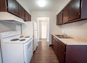 Thumbnail 11 of 25 - A kitchen with white appliances and dark wood cabinets.