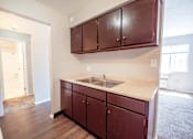 Thumbnail 12 of 25 - A kitchen with brown cabinets and a white counter top.