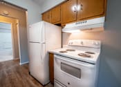 Thumbnail 3 of 25 - A white refrigerator and stove in a kitchen.