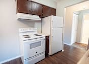 Thumbnail 13 of 25 - A white stove and refrigerator in a kitchen.